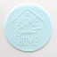 A round, light blue fondant plaque featuring the embossed text 'HOME Sweet HOME' with a small house outline and heart at the top, set against a plain off-white background.
