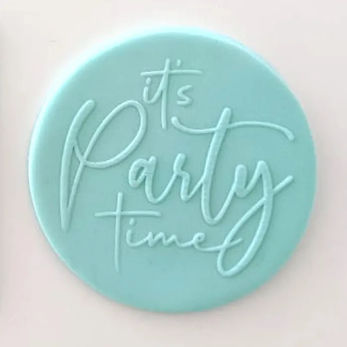 a fondant plaque in teal blue. It reads It's Party time