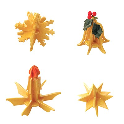 Four small decorative holiday ornaments made of icing  arranged on a plain white background: a yellow snowflake-like piece, a yellow bell-shaped piece with red berries and green holly leaves, a yellow starburst-like piece with a red top, and a yellow multi-pointed starburst piece.