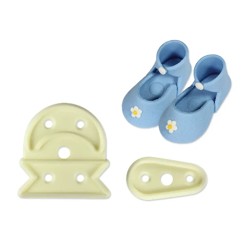 Plastic cutters to make baby bootees, alongside a finished gumpaste icing example of the boots