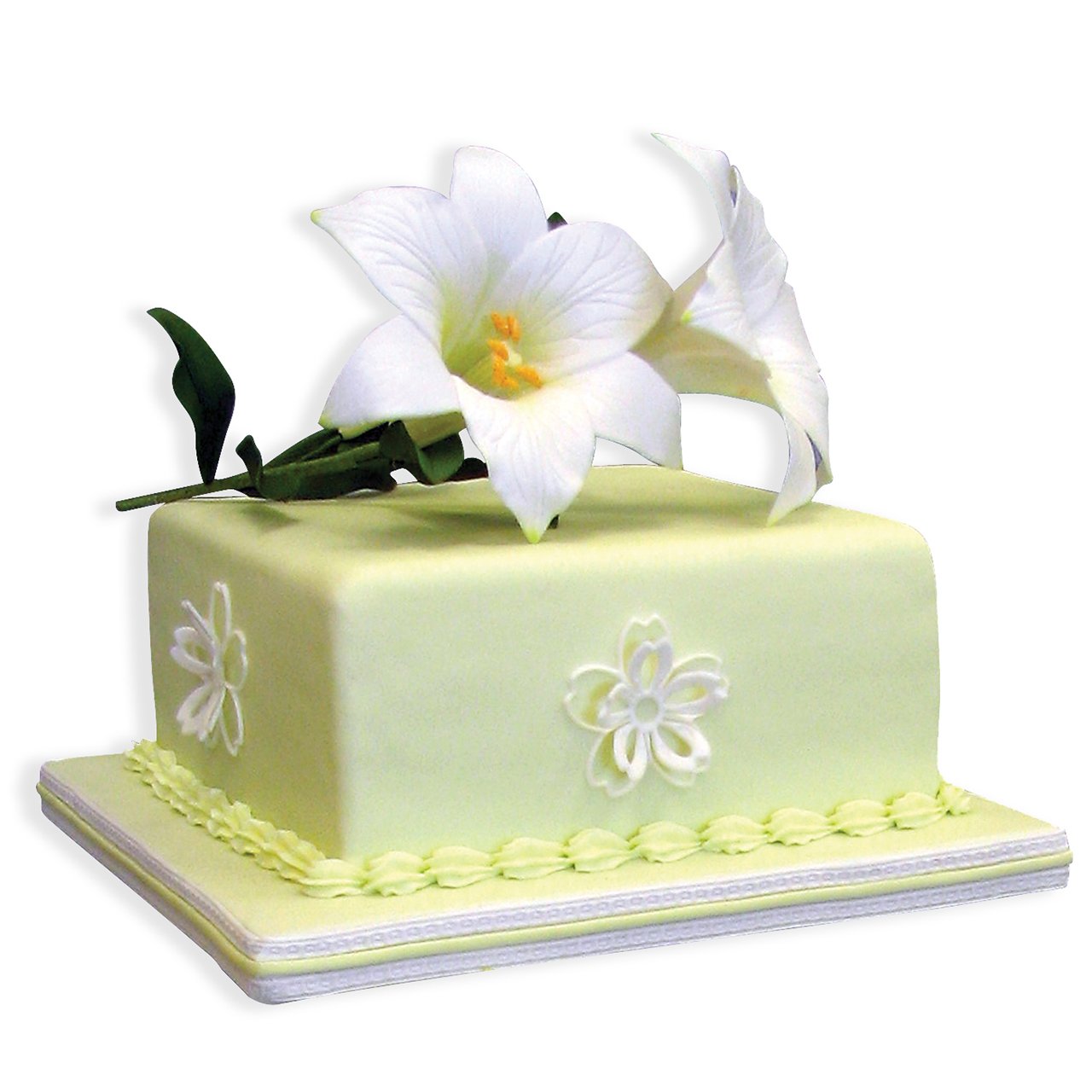 A square pale yellow-green cake decorated with white lily flowers and green leaves on top, set against a plain white background.
