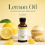 A bottle of lemon flavouringcentered on a pale yellow background, surrounded by lemons, a lemon cupcake, and gummy candies. Large text at the top reads 'Lemon Oil' with smaller supporting copy.