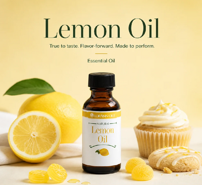 A bottle of lemon flavouringcentered on a pale yellow background, surrounded by lemons, a lemon cupcake, and gummy candies. Large text at the top reads 'Lemon Oil' with smaller supporting copy.