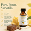 A bottle of Lorann Oils Natural Lemon Oil displayed next to lemon slices, a chocolate bar, and a bar of soap on a warm cream background with marketing text.