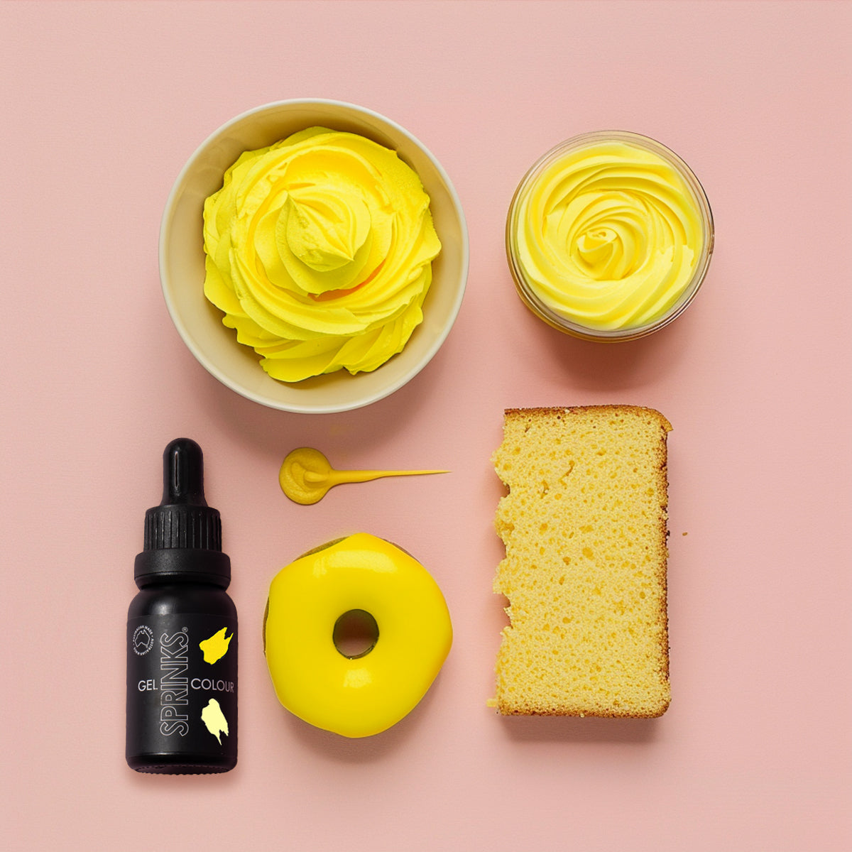 Yellow cake batter with a bottle, spoon, and cake on a pink background