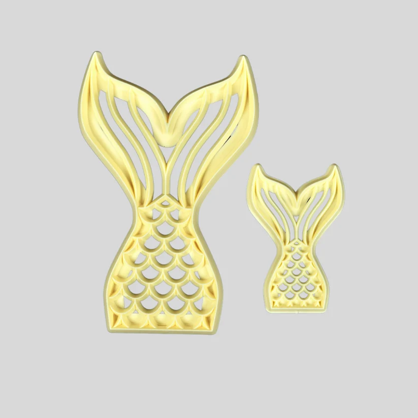 Two gold mermaid tail-shaped icing cutters, one large and one small, displayed on a solid light gray background.