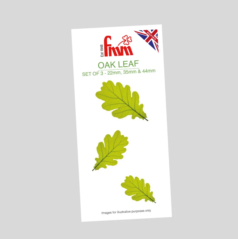 A package of three oak leaf in fondant icing on a plain light gray background. The white card reads 'fmm' with a small Union Jack flag and 'OAK LEAF' text, showing three green oak leaves of different sizes.