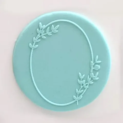 a teal fondant plaque embossed with an oval frame design