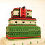 Three-tiered cake with green, red, and white patterns on a beige background