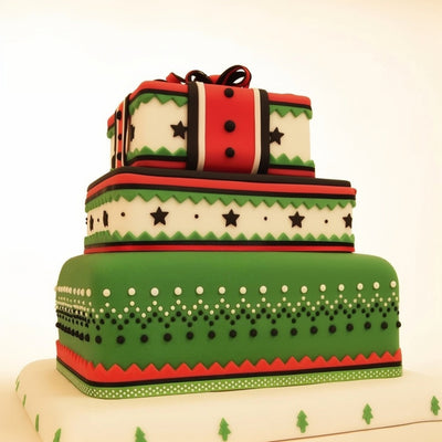 Three-tiered cake with green, red, and white patterns on a beige background