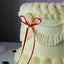 White cake with a red ribbon on a dark background