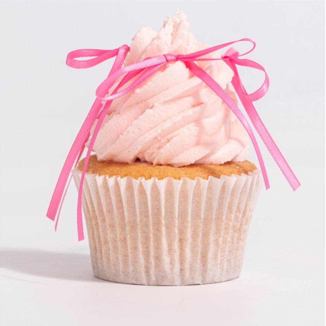Cupcake with pink frosting and a pink ribbon on a light gray background