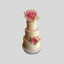 A three-tiered cream-colored cake decorated with pink rose flowers, pink ribbon bands, and small white floral accents, set against a solid light gray background.
