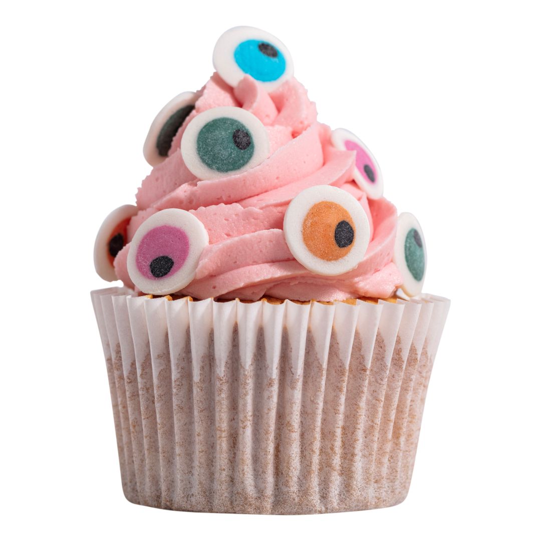 Cupcake with pink frosting and colorful candy eyes on a white background