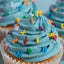 Cupcake with blue frosting and colorful letter sprinkles