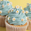 Cupcakes with blue frosting and white daisy decorations on a yellow background