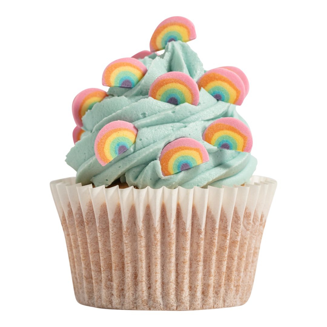 Cupcake with green frosting and rainbow decorations on a white background