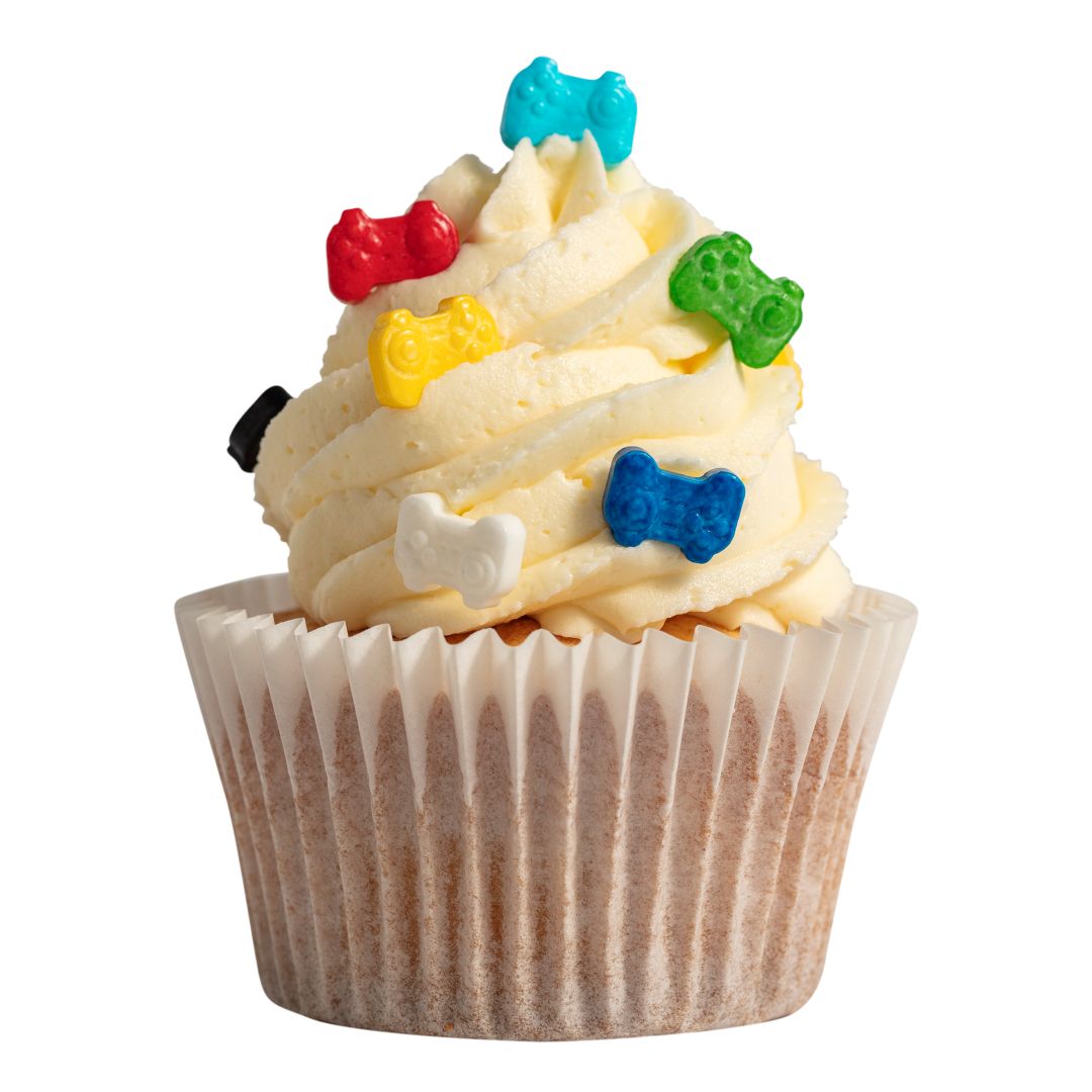 Cupcake with colorful candy game controller pieces on a white background