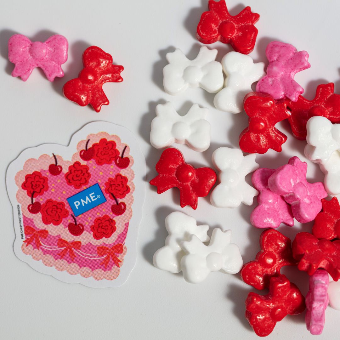 Decorative candies with red and pink bows and hearts on a white background, featuring a PME brand.