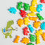 Colorful dinosaur-shaped sprinkles with a sticker of a green dinosaur playing guitar on a white background