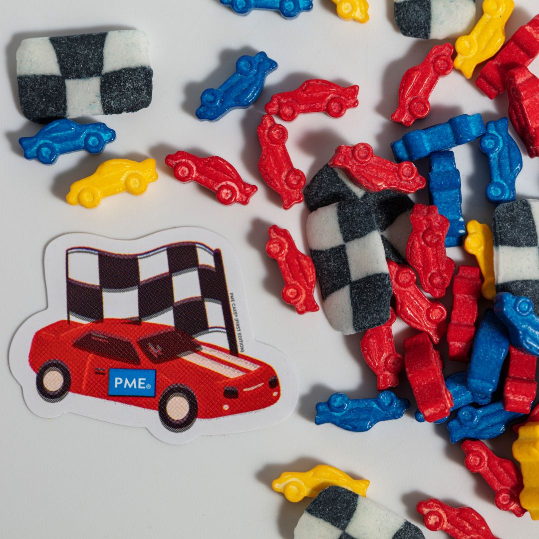Colorful race car-themed sprinkles with a checkered flag and red car sticker on a white background.