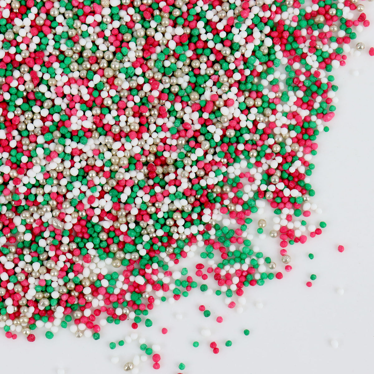 Colorful sprinkles in red, green, and white on a white background