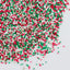 Colorful sprinkles in red, green, and white on a white background