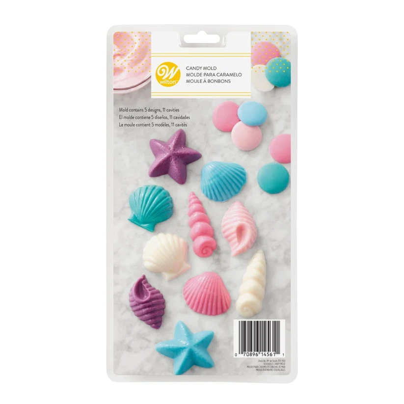 A Wilton brand candy mold, cshaped like seashells, a starfish, and seashells in various pastel and bright colors, displayed on a white marble-patterned backing card.