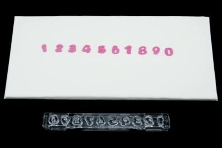 Small number plastic cutter with ejector. Alongside fondant icing examples made with the cutter