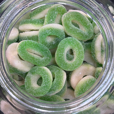 Sour gummy candy rings. Green apple colour with white base
