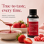 Lorann Better Than Extract Strawberry Emulsion bottle displayed next to a bowl of strawberry jam with a spoon dripping jam, fresh strawberries, and red-and-white striped  candies on a soft pink background.