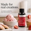 Lorann Better Than Extract Strawberry Emulsion bottle displayed next to a bowl of fresh strawberry ice cream and a cupcake