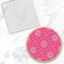 a clear acrylic debosser embossing tool with a pattern of all over flowers. Sitting alongside a finished example made using it of a pink cookie