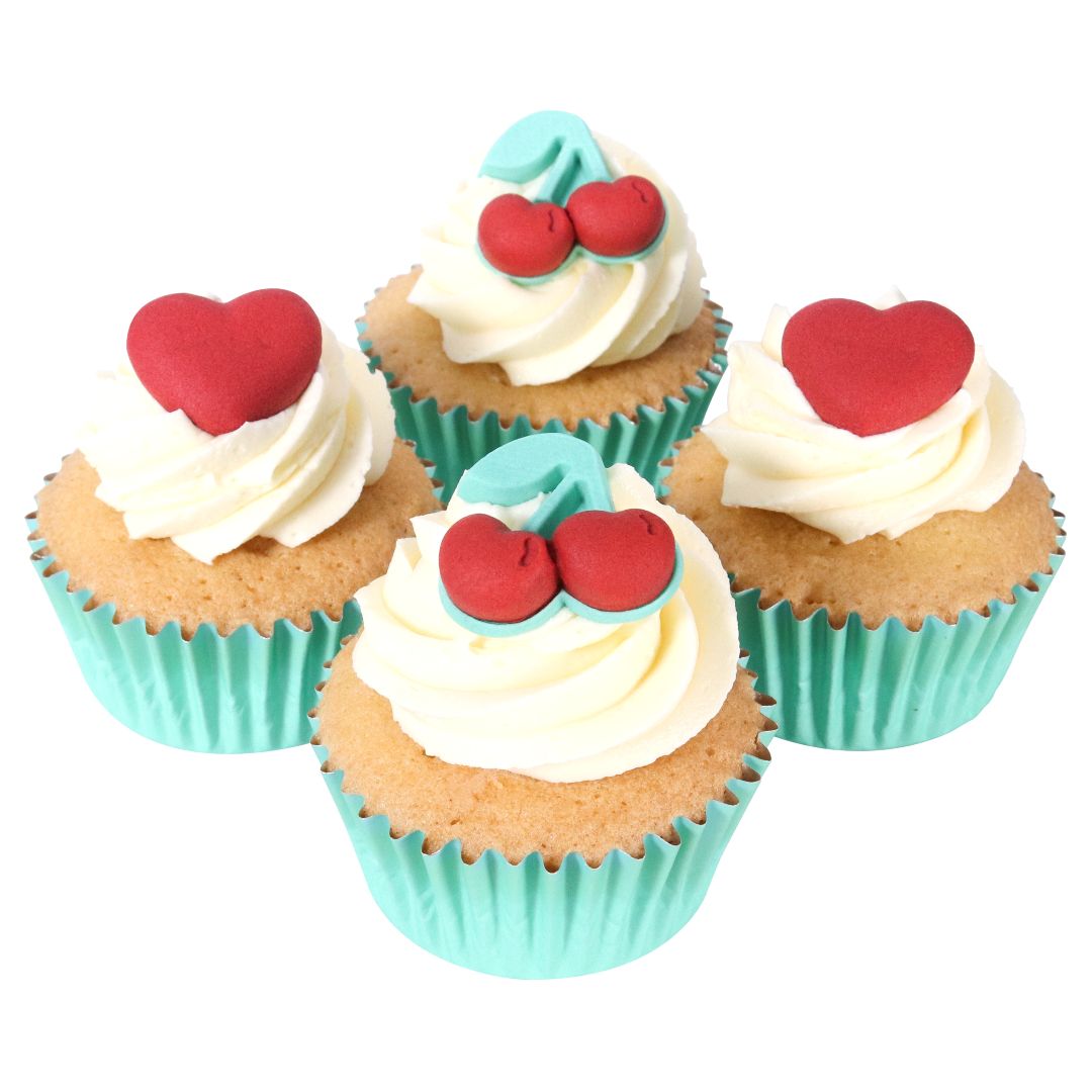 Four cupcakes with white frosting, red hearts, and cherries.