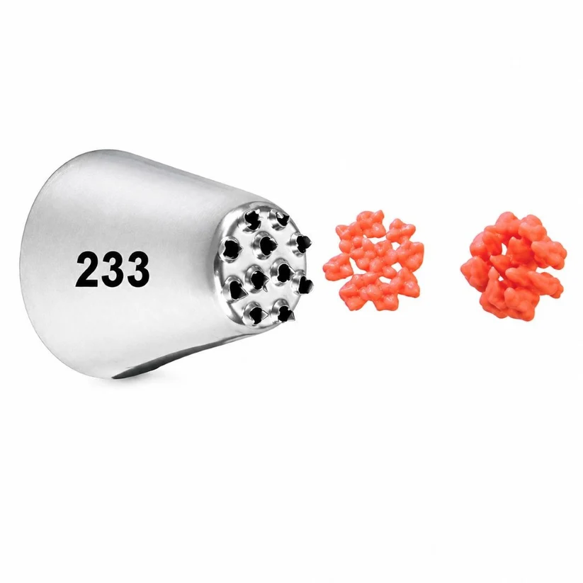 Metal baking tool with number 233 next to two red flower-shaped candies on a white background