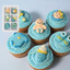 Decorative cupcakes with blue frosting and baby-themed decorations