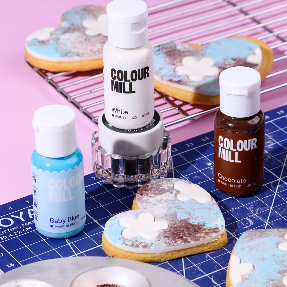 Colour Mill paint bottles alongside a decorated painted cookie.