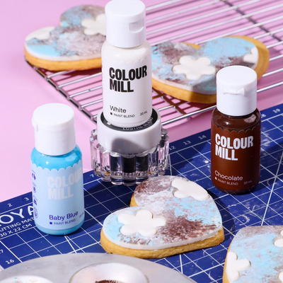 Colour Mill paint bottles alongside a decorated painted cookie.