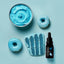 Blue-themed dessert set with blue frosting, cake, and donuts on a light blue background.