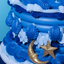 Blue tiered cake with star and moon decorations on a light blue background