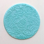 Round blue fondant circle with Easter-themed designs on a light pink background