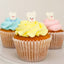 Three decorated cupcakes on a white plate, each topped with a swirl of frosting in light blue, pale yellow, and pale pink, with small white bunny toppers on top.