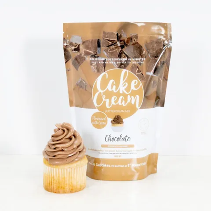 Bag of Cake Cream chocolate buttercream frosting next to a cupcake with chocolate frosting on a white background