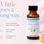 A bottle of LorAnn Oils Super Strength Cotton Candy Flavor essential oil shown on a soft pink background with marketing text and a cupcake prop.