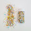 Colorful sprinkles and a container on a white background with unicorn horns and pretty colour sprinkles