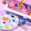 Colorful cake art supplies including a paint palette, brush, and Colour Mill product on a pink background