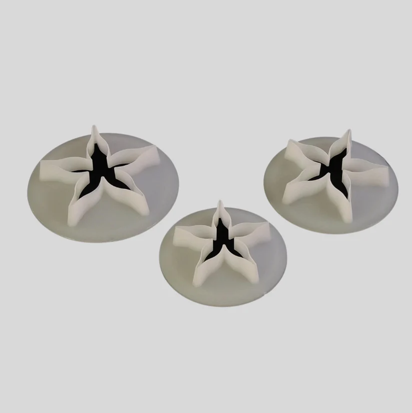 Three calyx cutters with a star-like shape, arranged on a light gray background.