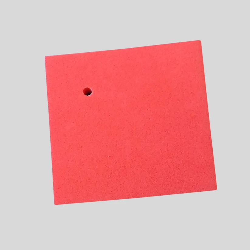 A square red foam pad with a small pre-drilled hole near the top-left corner, shown on a solid light gray background.