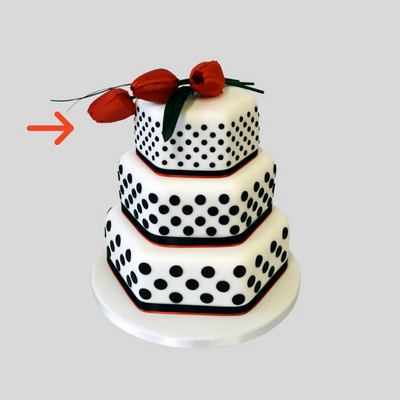 a cake with black polka dots on white fondant. Made with three tiers