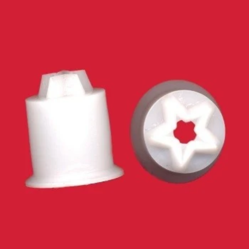Two small white plastic star cutters on a solid red background, one upright and one viewed from the side with a star-shaped recess.